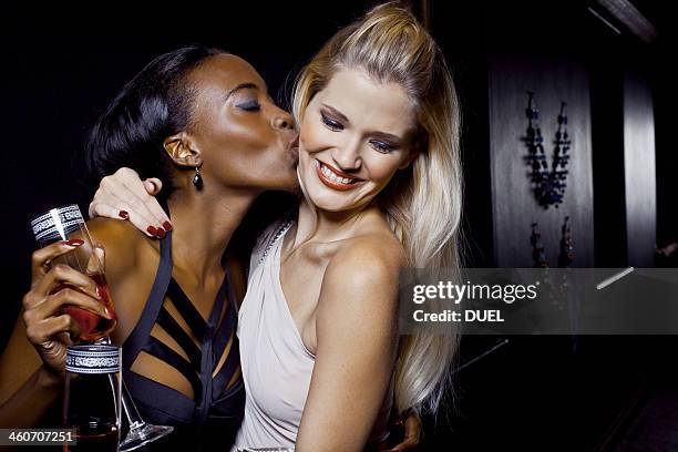 two female friends hugging and kissing in nightclub - black lesbians kiss stock pictures, royalty-free photos & images