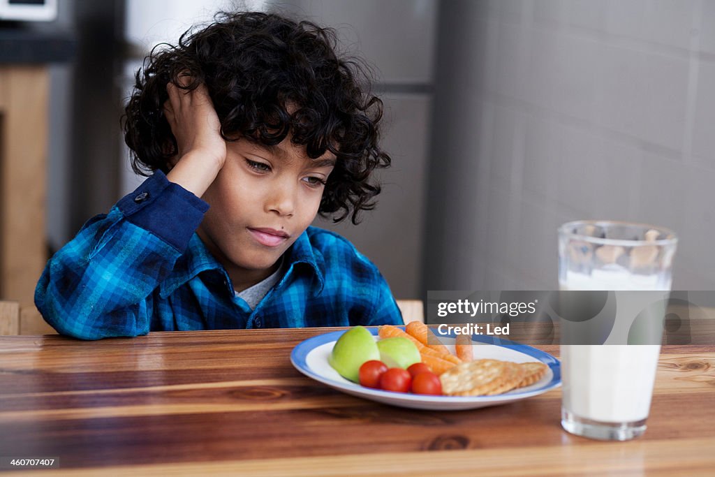 Boy staring at snacks and glass of milk