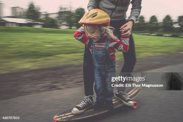 mother and daughter riding on skateboard in park - skateboarding moms photos et images de collection