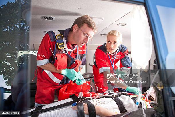 paramedics working on patient in ambulance - stretcher photos et images de collection