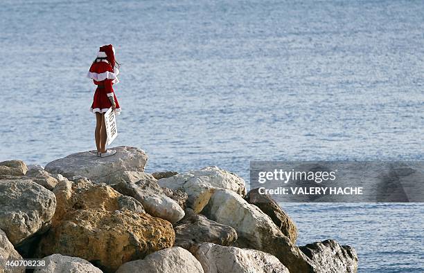 Member of the French anti-fur group "CAFT" , dressed up as Santa Claus, looks at the sea during a demonstration on December 20 in Nice, southeastern...