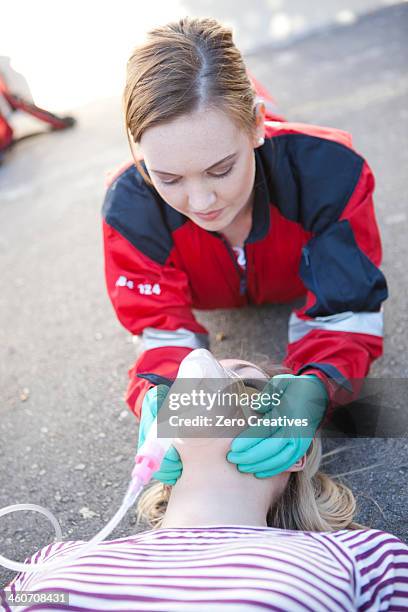 female paramedic tending patient on road - adrenaline stress stock pictures, royalty-free photos & images