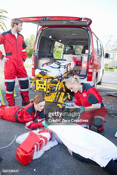 ambulance and paramedics attending patient on road - adrenaline stress stock pictures, royalty-free photos & images