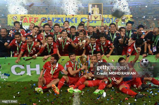 Thailand players celebrate with the trophy after winning the AFF Suzuki Cup 2014 second-leg final football match against Malaysia at the Bukit Jalil...