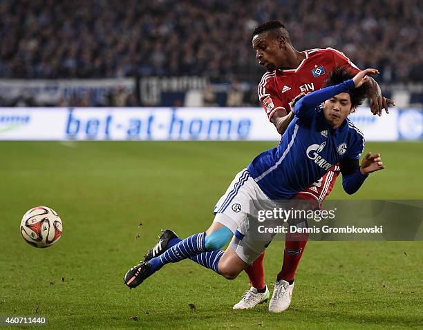 Atsuto Uchida of FC Schalke 04 is challenged by Cleber of Hamburger SV during the Bundesliga match between FC Schalke 04 and Hamburger SV at Veltins...