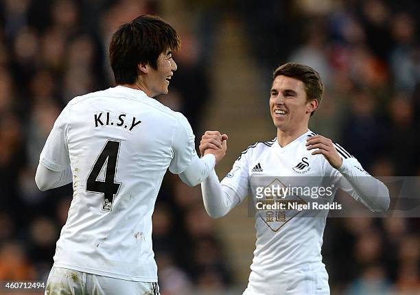 Ki Sung-Yueng of Swansea City celebrates scoring the opening goal with team-mate Tom Carroll during the Barclays Premier League match between Hull...