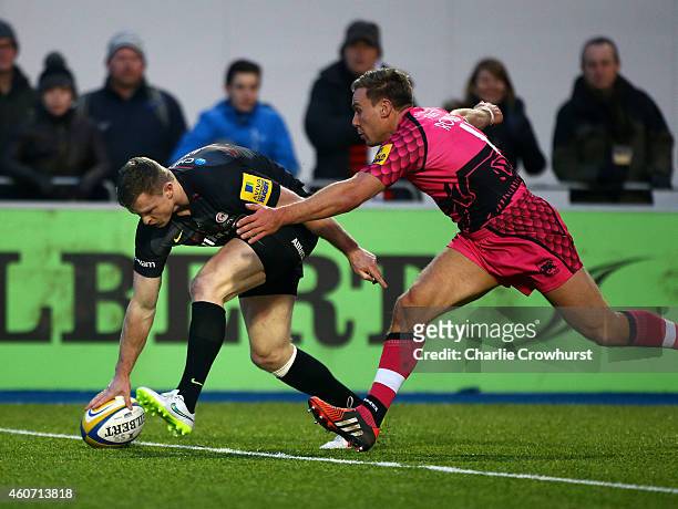 Chris Ashton of Saracens goes over to score another try despite the best efforts of London Welsh's Will Robinson to prevent him during the Aviva...