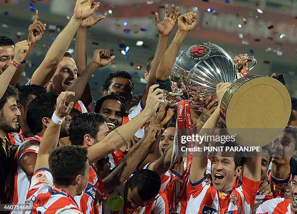Atletico de Kolkata player Luis Garcia lifts the trophy as he celebrates with teammates after winning the Indian Super League final football match...