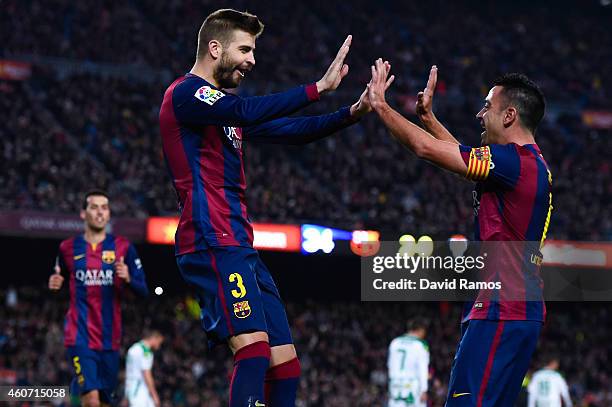 Gerard Pique of FC Barcelona celebrates with his teammate Xavi Hernandez of FC Barcelona after scoring his team's third goal during the La Liga match...