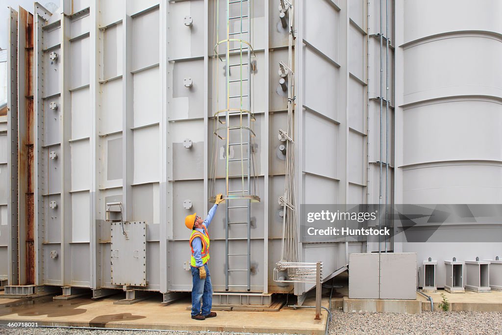 Engineer at sound suppression stage of gas turbine which drives generators in power plant