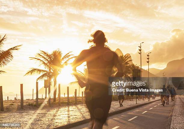 man jogging on the beach of ipanema at sunset - rio de janeiro street stock pictures, royalty-free photos & images