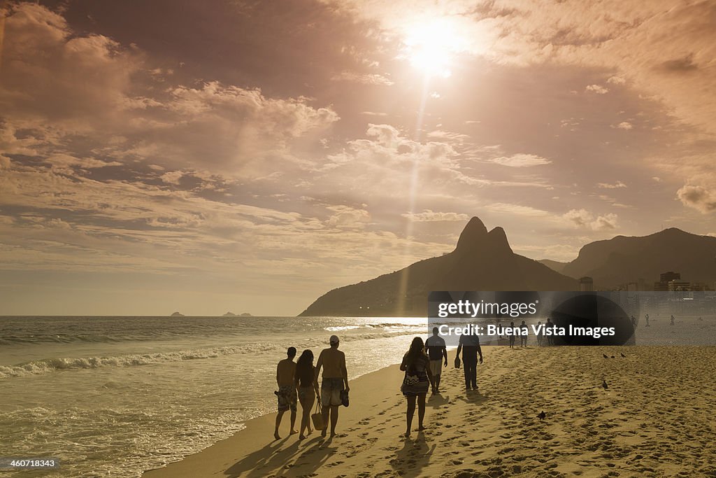 People walking on the beach at sunset
