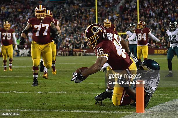 Running back Alfred Morris of the Washington Redskins scores a first quarter touchdown against the defense of free safety Malcolm Jenkins of the...