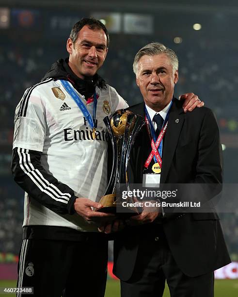 Real Madrid head coach Carlo Ancelotti and his assistant Paul Clement pose with the trophy following the FIFA Club World Cup Final match between Real...