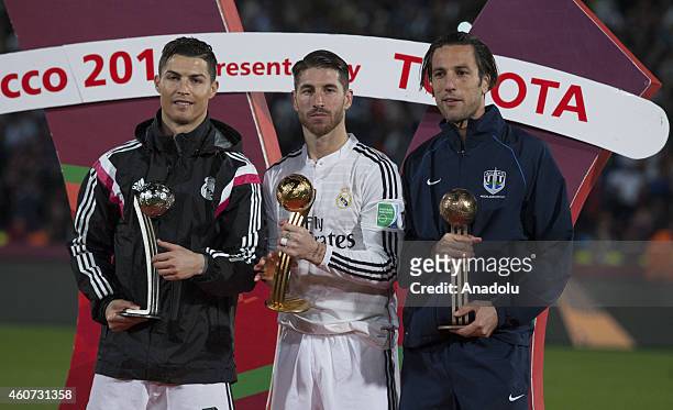 Cristiano Ronaldo of Real Madrid receives the adidas Silver Ball, Sergio Ramos of Real Madrid receives the adidas Golden Ball and Ivan Vicelich of...