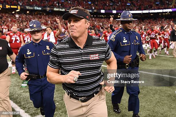 Head coach Mark Hudspeth of the Louisiana-Lafayette Ragin Cajuns runs to midfield following a victory over the Nevada Wolf Pack in the R&L Carriers...