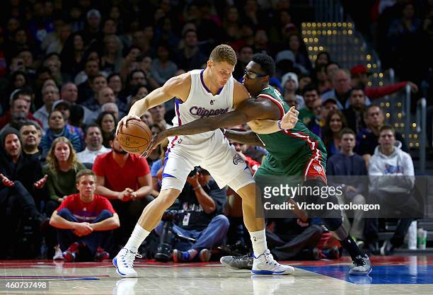 Larry Sanders of the Milwaukee Bucks reaches for the ball as Blake Griffin of the Los Angeles Clippers keeps the ball from Sanders' reach in the...