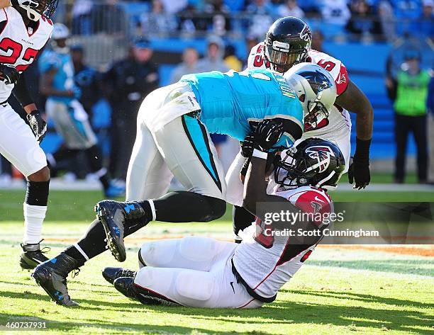 Cam Newton of the Carolina Panthers scrambles against Stansly Maponga of the Atlanta Falcons at Bank of America Stadium on November 3, 2013 in...