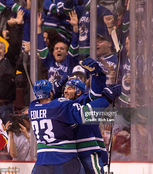 Christopher Tanev of the Vancouver Canucks celebrates with Alexander Edler after scoring the game winning goal against the Calgary Flames in overtime...