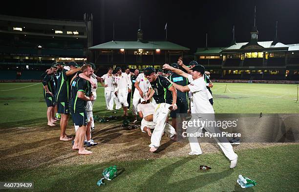 Chris Rogers of Australia pours beer on David Warner of Australia before singing the team song on the pitch at midnight after day three of the Fifth...