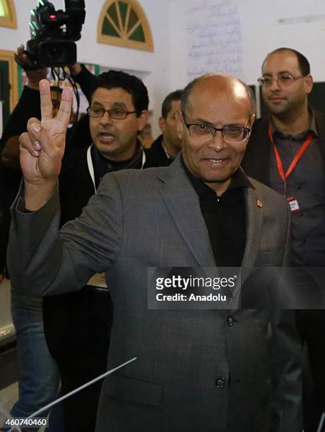 Tunisian presidential candidate Moncef Marzouki flashes victory sign after casting his vote at Sidi el Kantaoui school during the second round of...