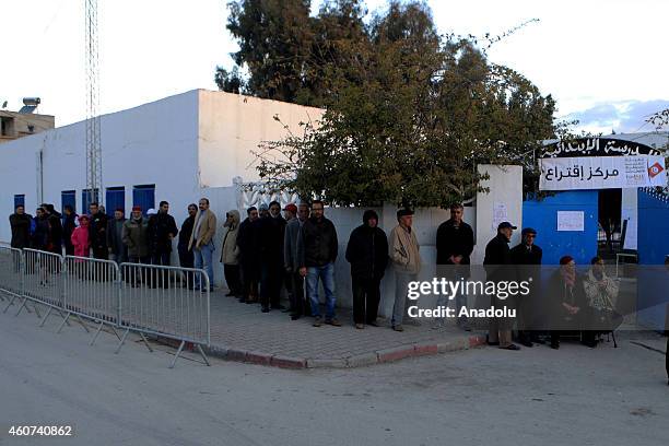 Tunisians wait in line to cast their ballots to elect the country's next president in a runoff vote at Nehic Elkrivan school in Ben Arous, Tunisia on...