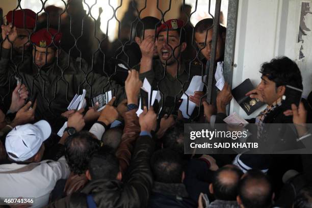 Palestinians await permission to enter Egypt as they gather inside the Rafah border crossing between Egypt and southern Gaza Strip on December 21,...