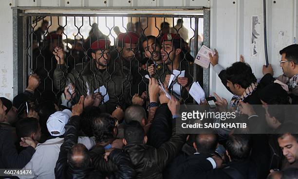 Palestinians await permission to enter Egypt as they gather inside the Rafah border crossing between Egypt and southern Gaza Strip on December 21,...