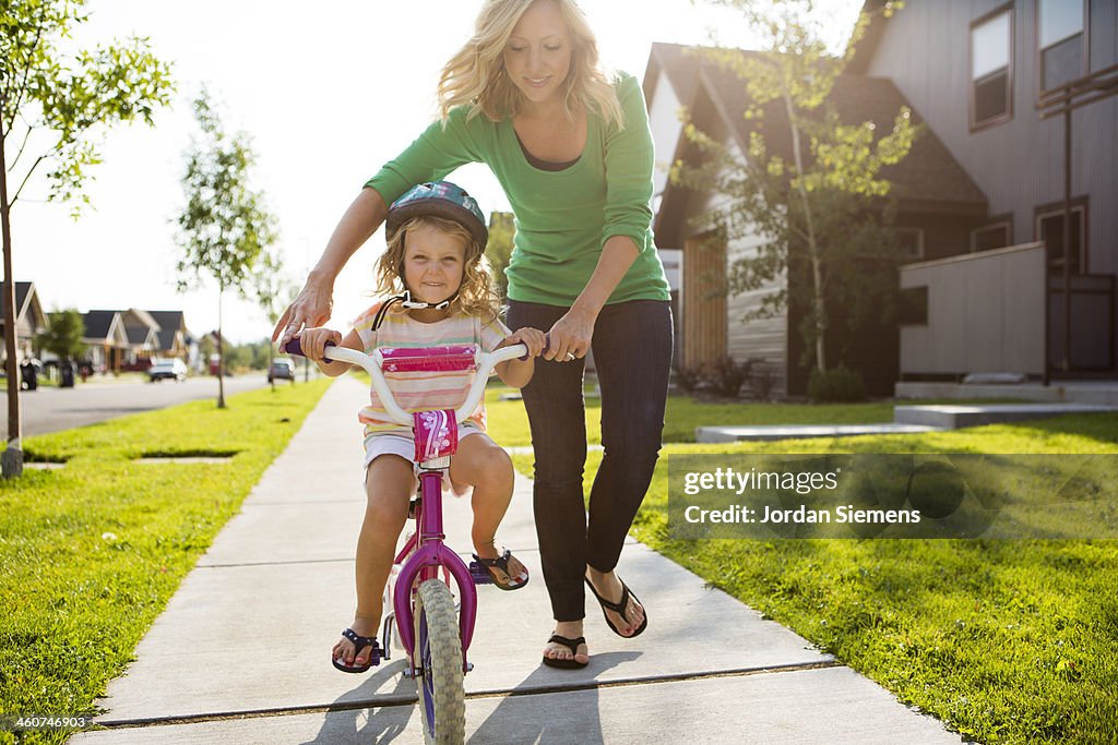 Young girl learning to ride a bike.