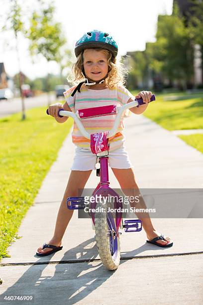 kid learning to ride a bike. - girl bike stock pictures, royalty-free photos & images