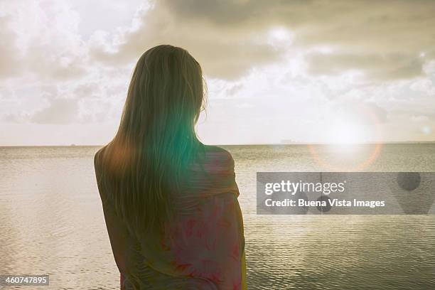 Woman on the beach watching the horizon