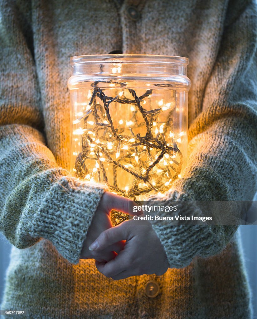 Woman with christmas lights in a jar