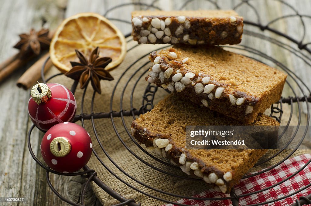 Gingerbread cake with christmas baubles and dried orange, spice on wooden table, close up