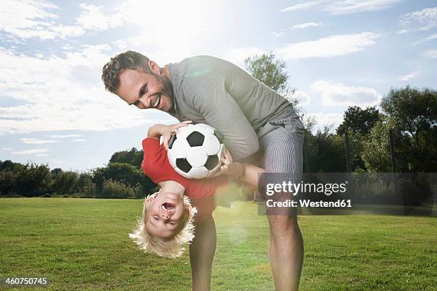 germany, cologne, father and son playing soccer - family soccer stock-fotos und bilder