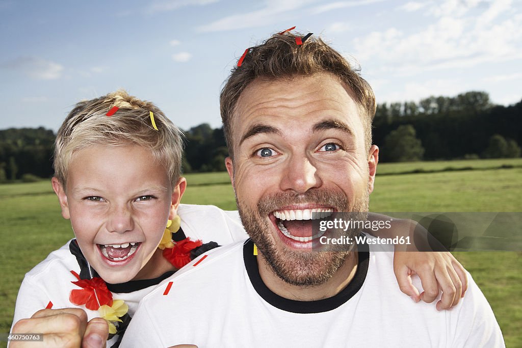 Germany, Cologne, Father and son supporting their soccer team