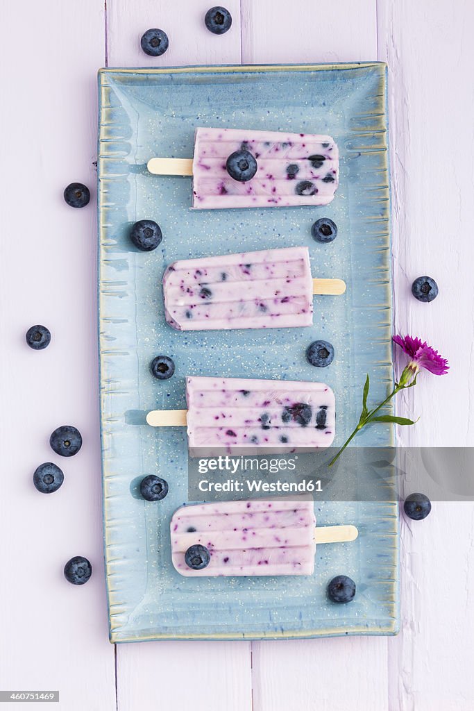 Blueberry yogurt with candy on tray, close up