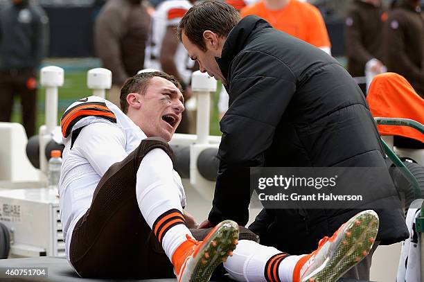 Trainer tends to Johnny Manziel of the Cleveland Browns after he was imjured during their game against the Carolina Panthers at Bank of America...