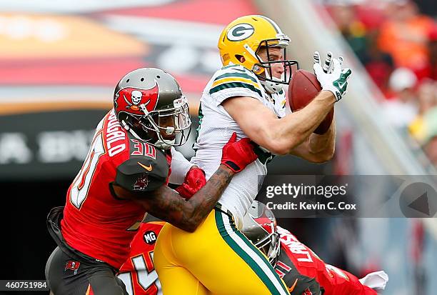 Jordy Nelson of the Green Bay Packers pulls in this reception against Bradley McDougald, Lavonte David of the Tampa Bay Buccaneers, and Danny...