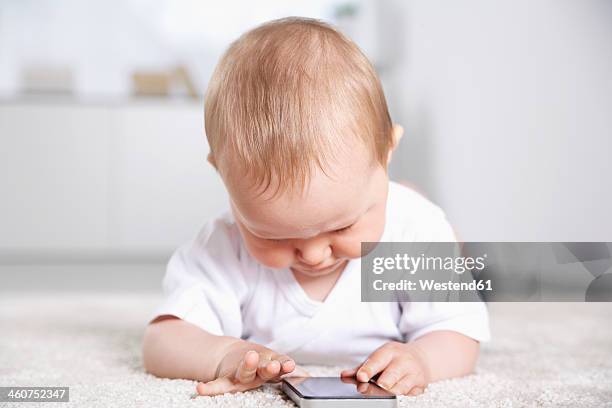 germany, north rhine westphalia, cologne, baby girl playing with mobile phone - baby smartphone stock pictures, royalty-free photos & images