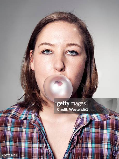 portrait of young woman blowing bubble gum - bubble gum bubble stock pictures, royalty-free photos & images