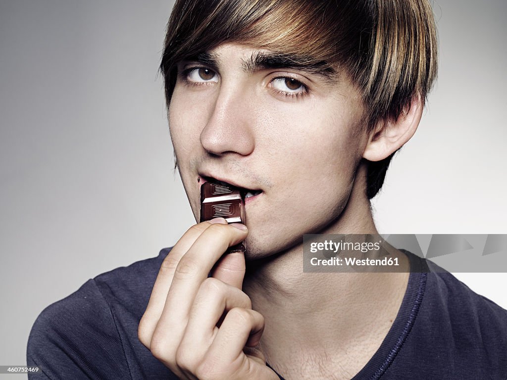 Portrait of Young man eating chocolate