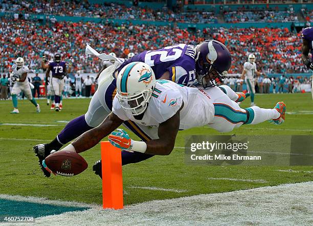 Wide receiver Mike Wallace of the Miami Dolphins scores a third quarter touchdown as free safety Harrison Smith of the Minnesota Vikings defends...