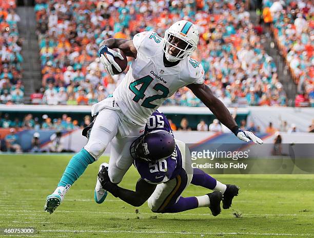 Tight end Charles Clay of the Miami Dolphins is brought down by outside linebacker Gerald Hodges of the Minnesota Vikings in the third quarter during...