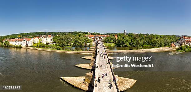 germany, bavaria, regensburg, view of stadtamhof, old stone bridge crossing danube river with danube island - regensburg stock-fotos und bilder