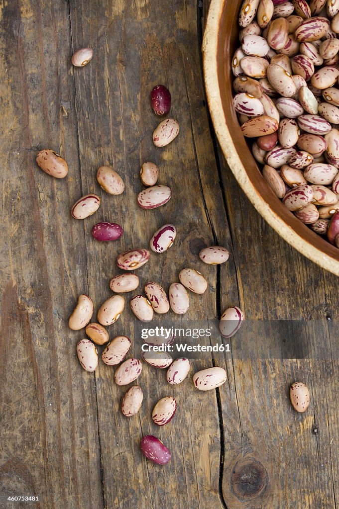 Bowl of borlotti beans on wooden table, close up