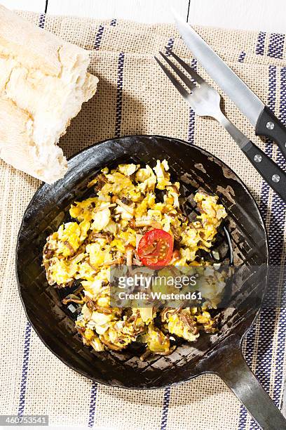 scrambled eggs with enoki mushrooms and onions in pan, close up - enoki mushroom stock-fotos und bilder