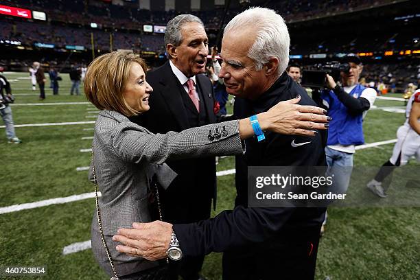 Head coach Mike Smith of the Atlanta Falcons greets Angela Macuga following a game against the New Orleans Saints at the Mercedes-Benz Superdome on...