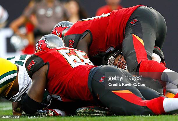 Josh McCown of the Tampa Bay Buccaneers is sacked by Clay Matthews and Datone Jones of the Green Bay Packers at Raymond James Stadium on December 21,...
