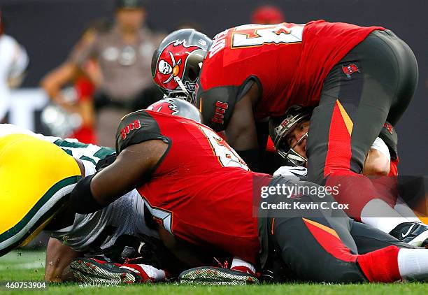 Josh McCown of the Tampa Bay Buccaneers is sacked by Clay Matthews and Datone Jones of the Green Bay Packers at Raymond James Stadium on December 21,...