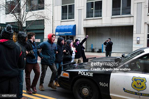 Protestors block police cruisers on Ontario Street December 21 in Cleveland, Ohio. Demonstrators marched through downtown protesting the death of...